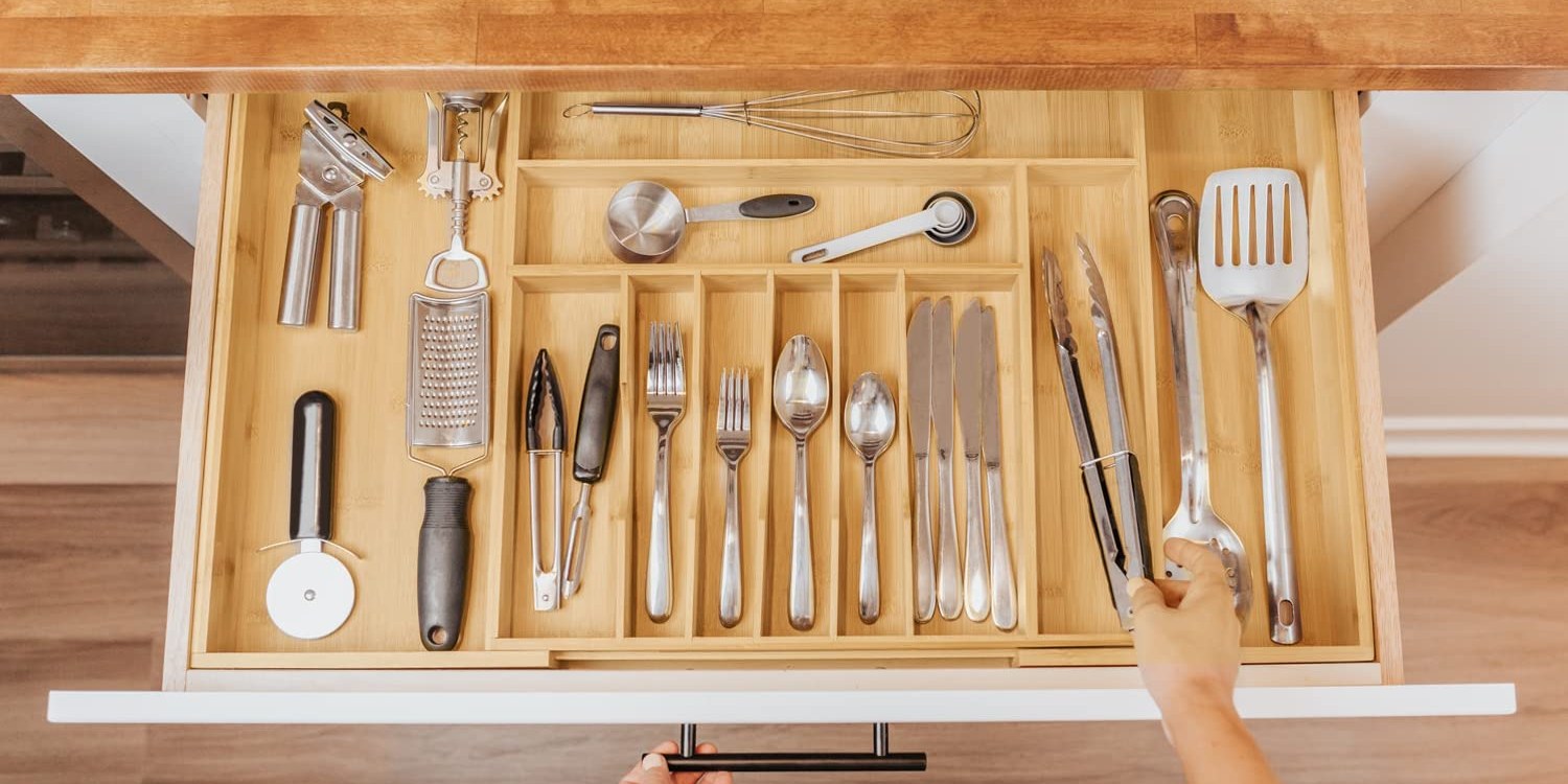 Kitchen tools sorted into a bamboo drawer organizer